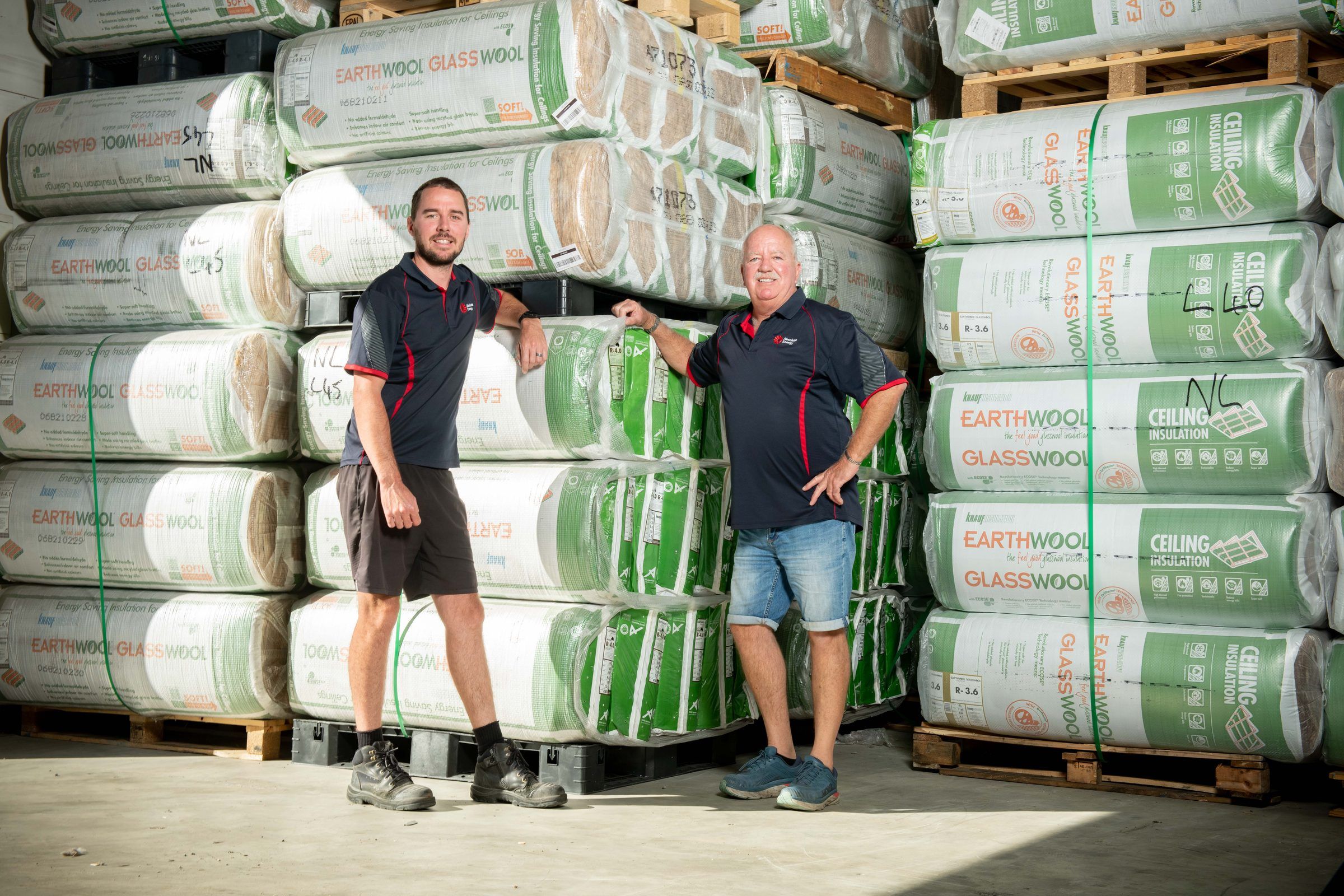 Troy and Paul Brockie among stacked insulation in the warehouse