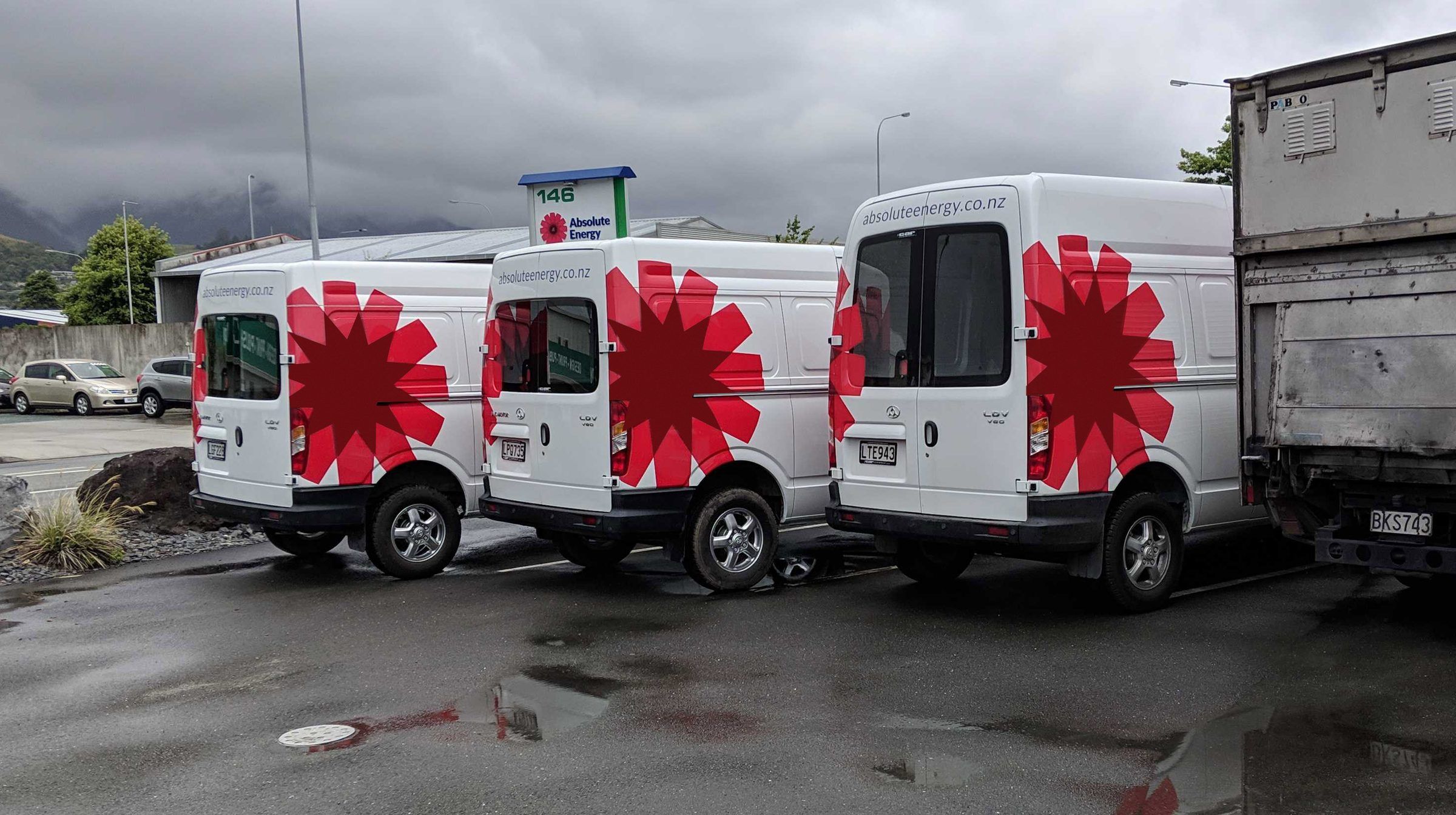 A row of white vans in the new red livery
