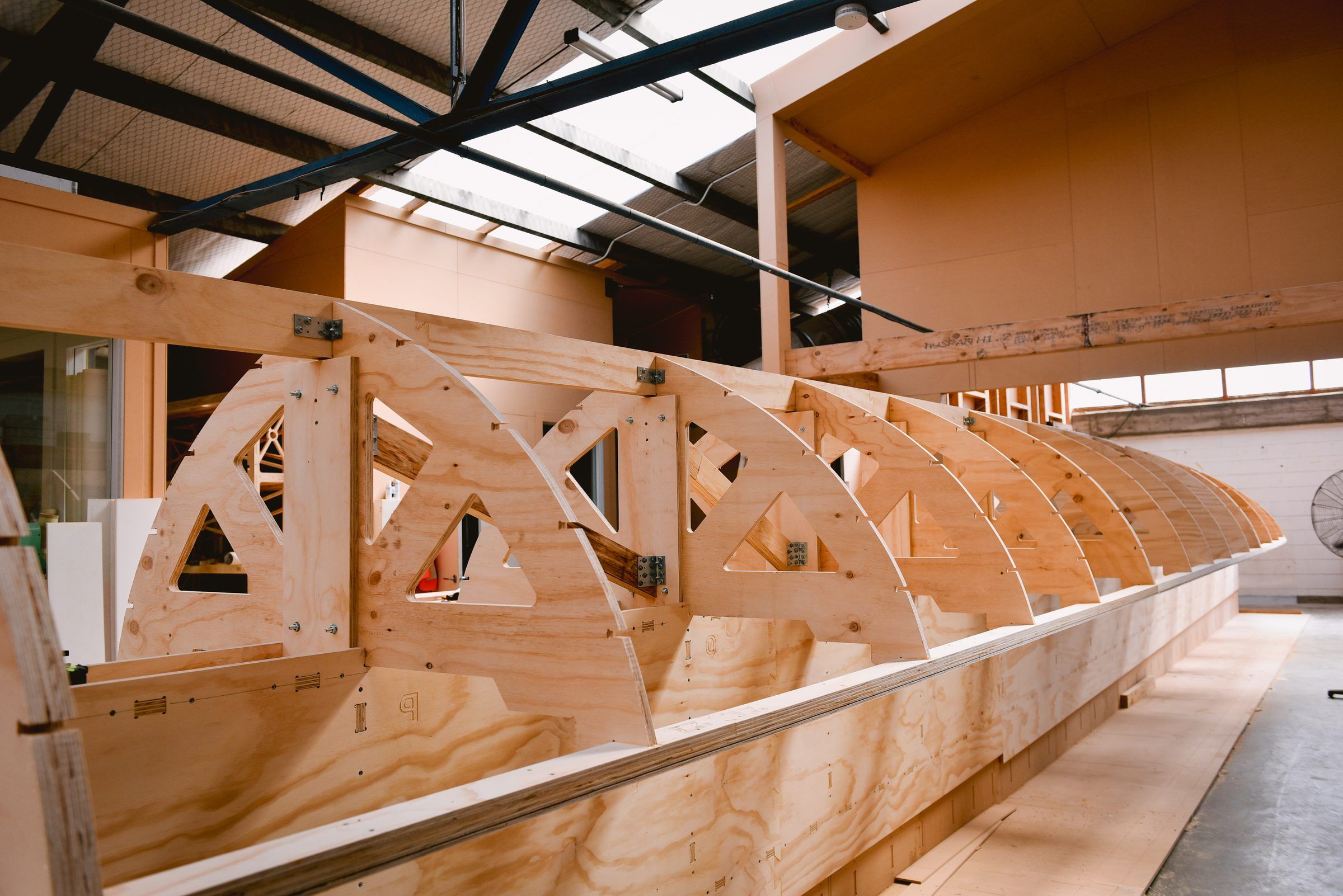 The timber frame of the waka under construction in the workshop