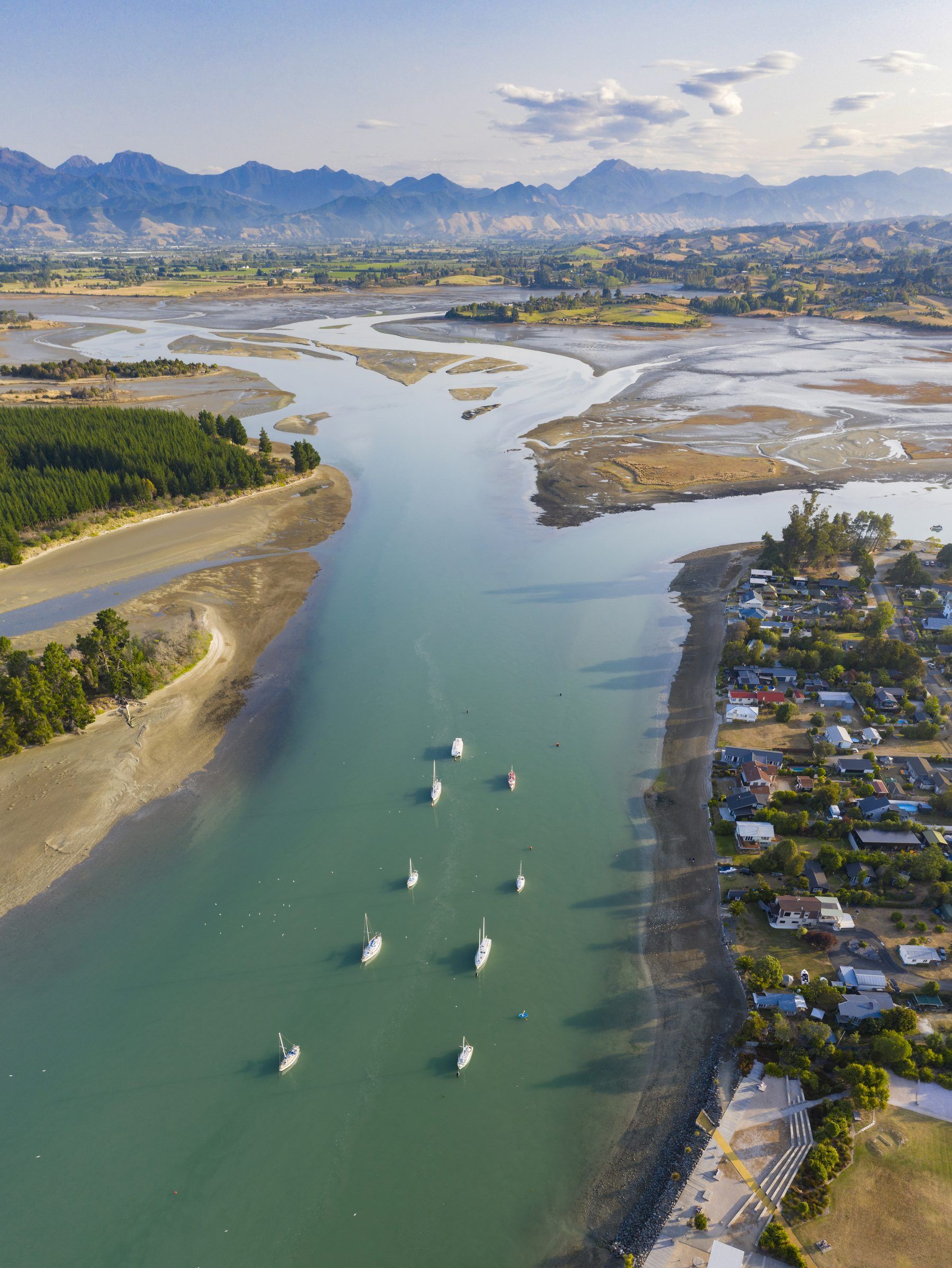 Aerial view of an estuary and coastline with mountains beyond