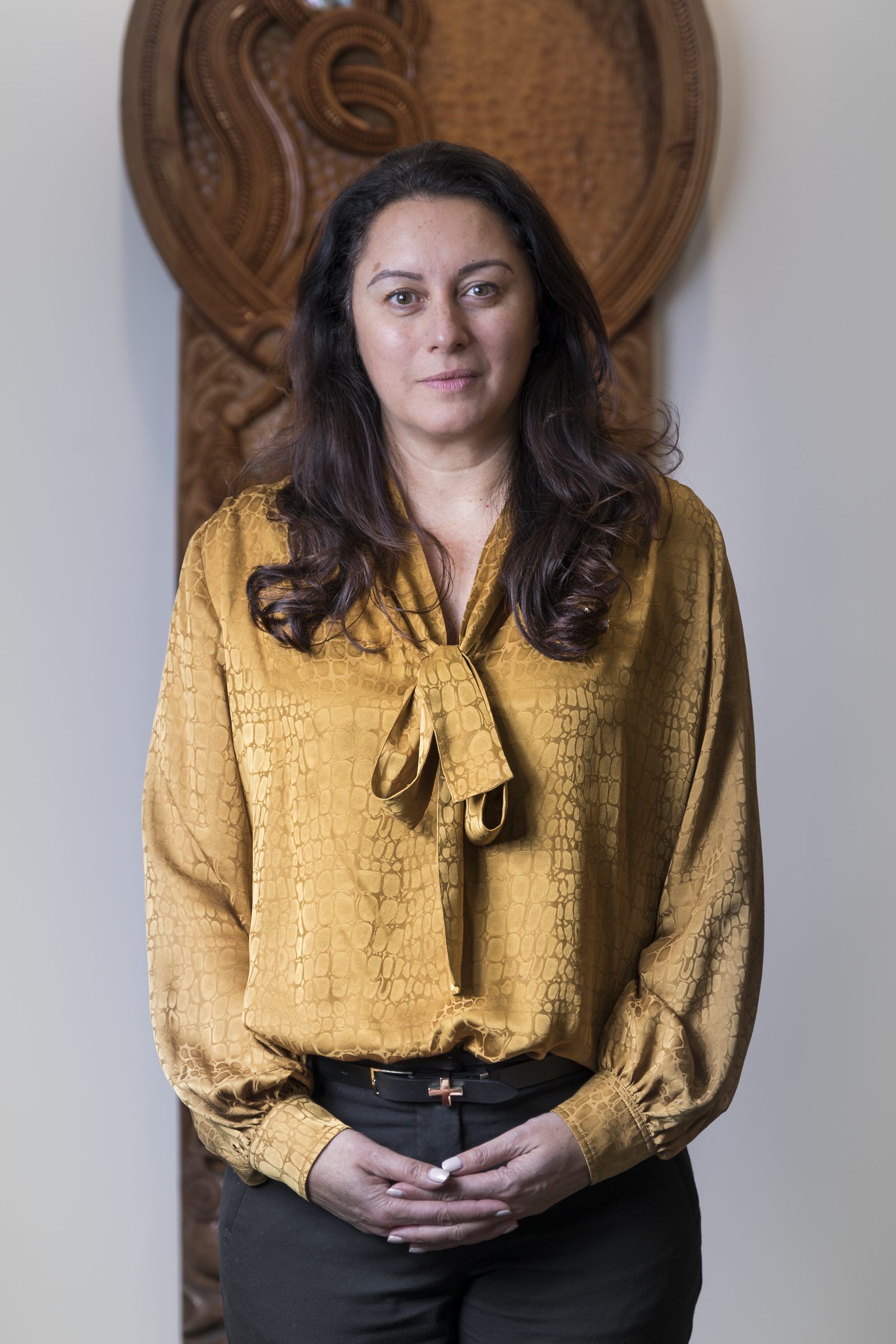 Portrait of a woman standing in front of carved panels