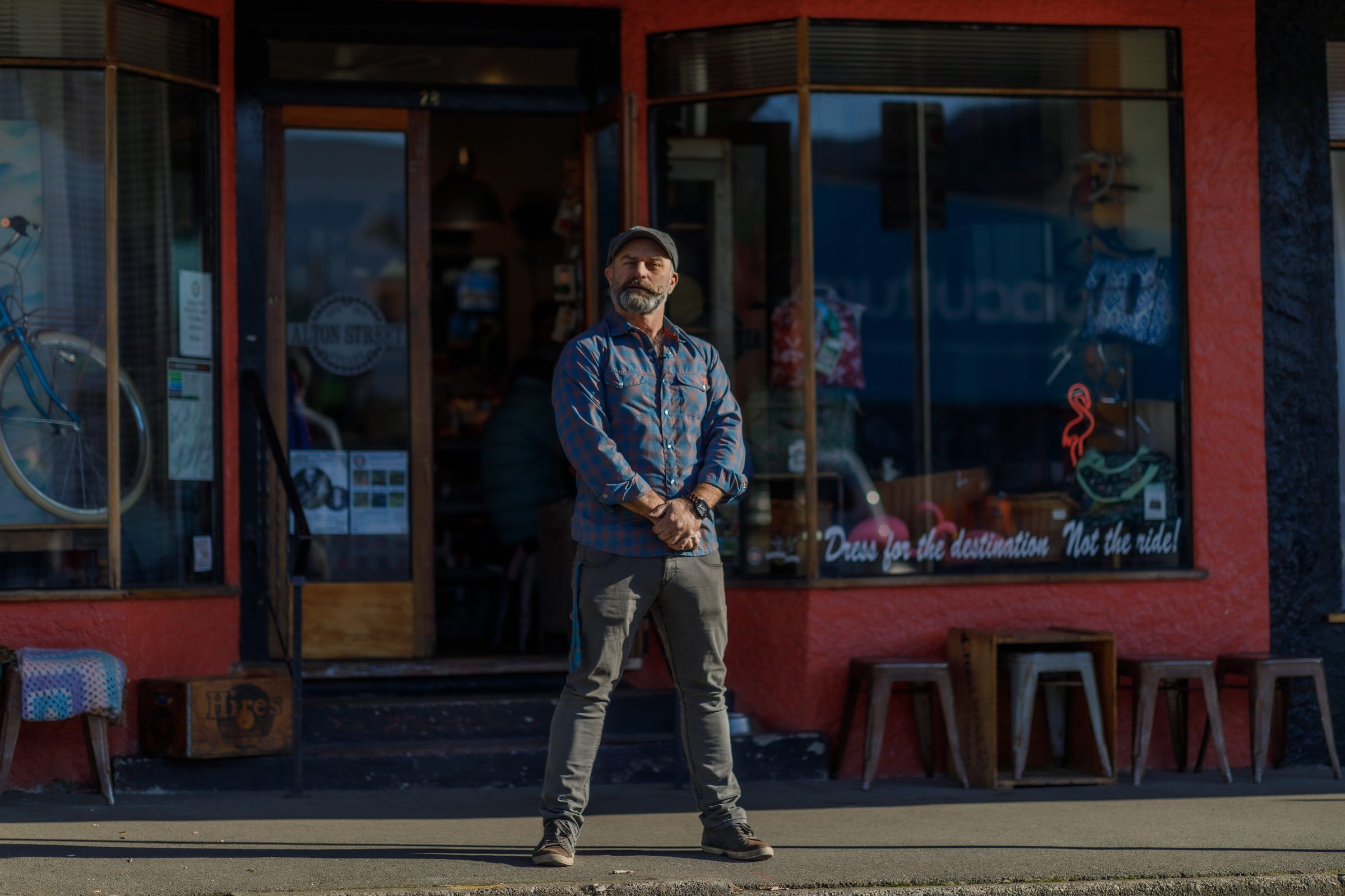 A business owner stands outside his shopfront