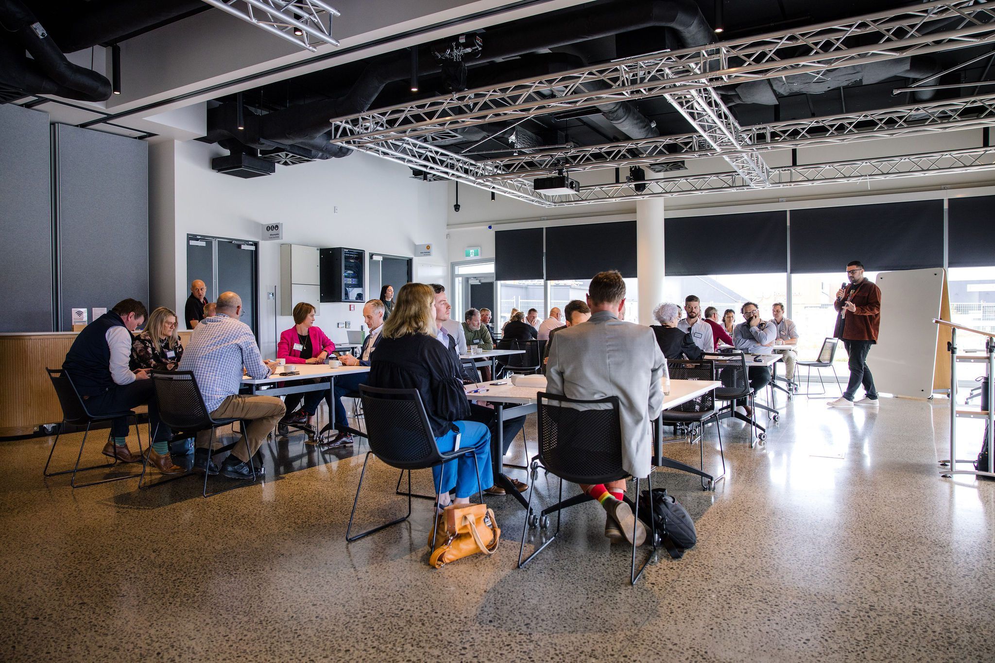 Participants working at tables across a large room