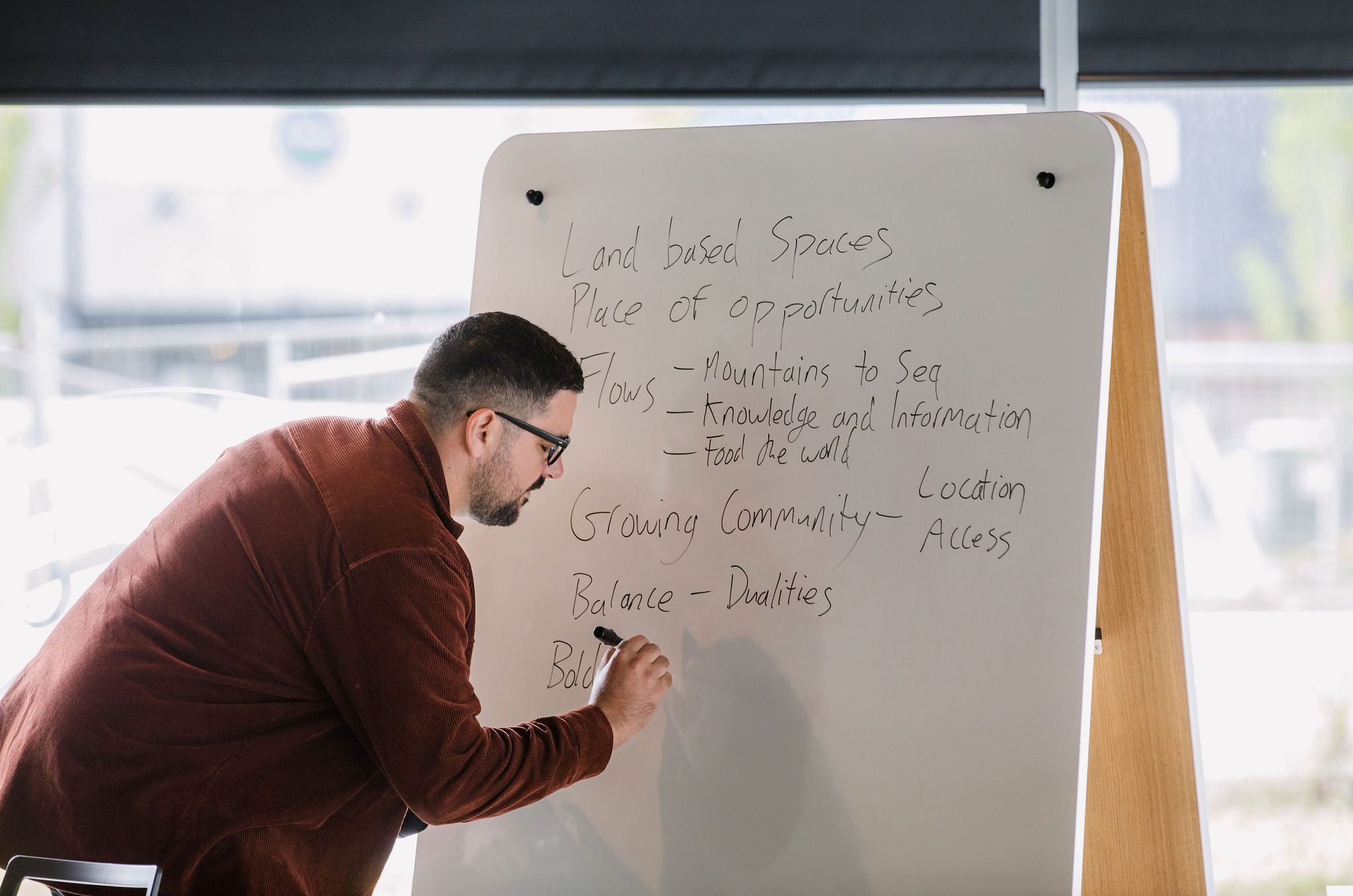 Johny O’Donnell writes themes on a whiteboard during a forum