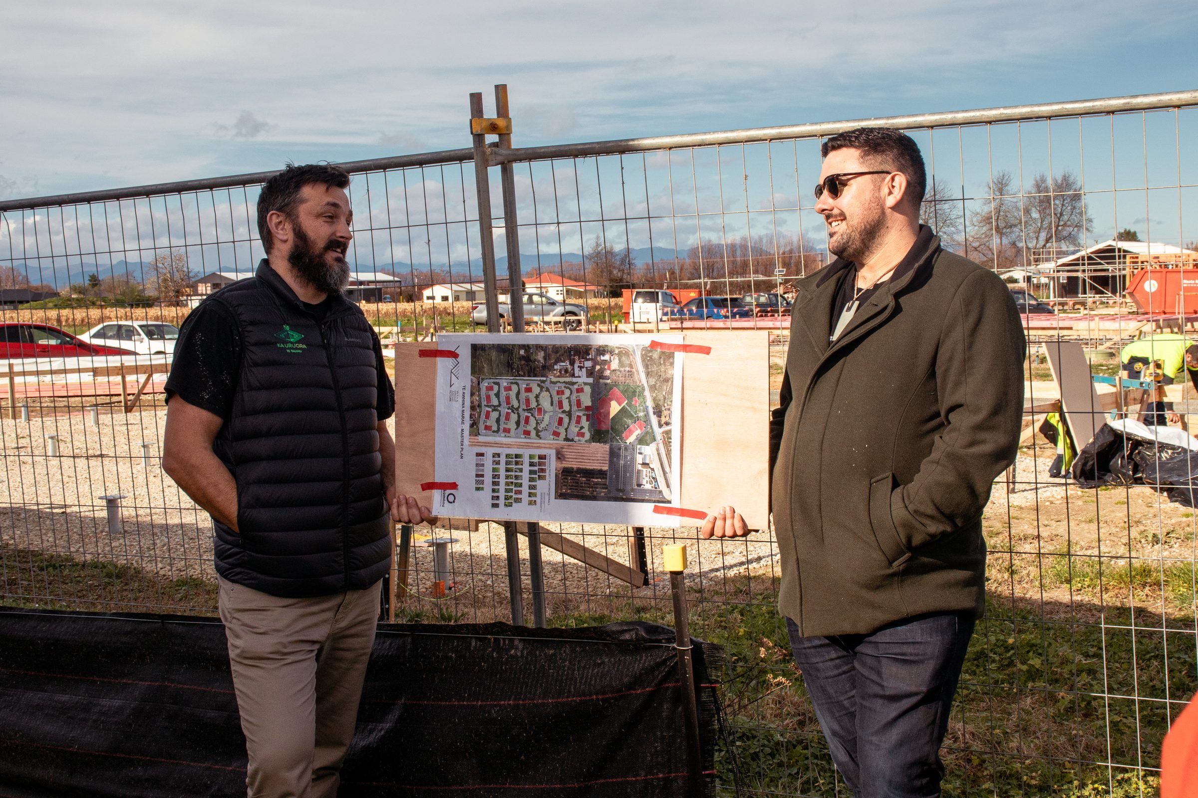 Johny O’Donnell and a member of the build team discuss the site plan at the construction fence