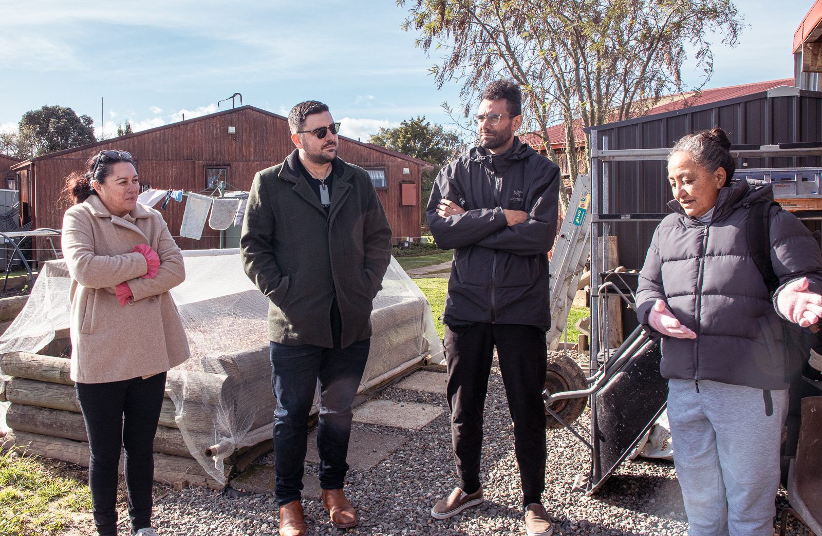 Whānau and the project team talk on the building site