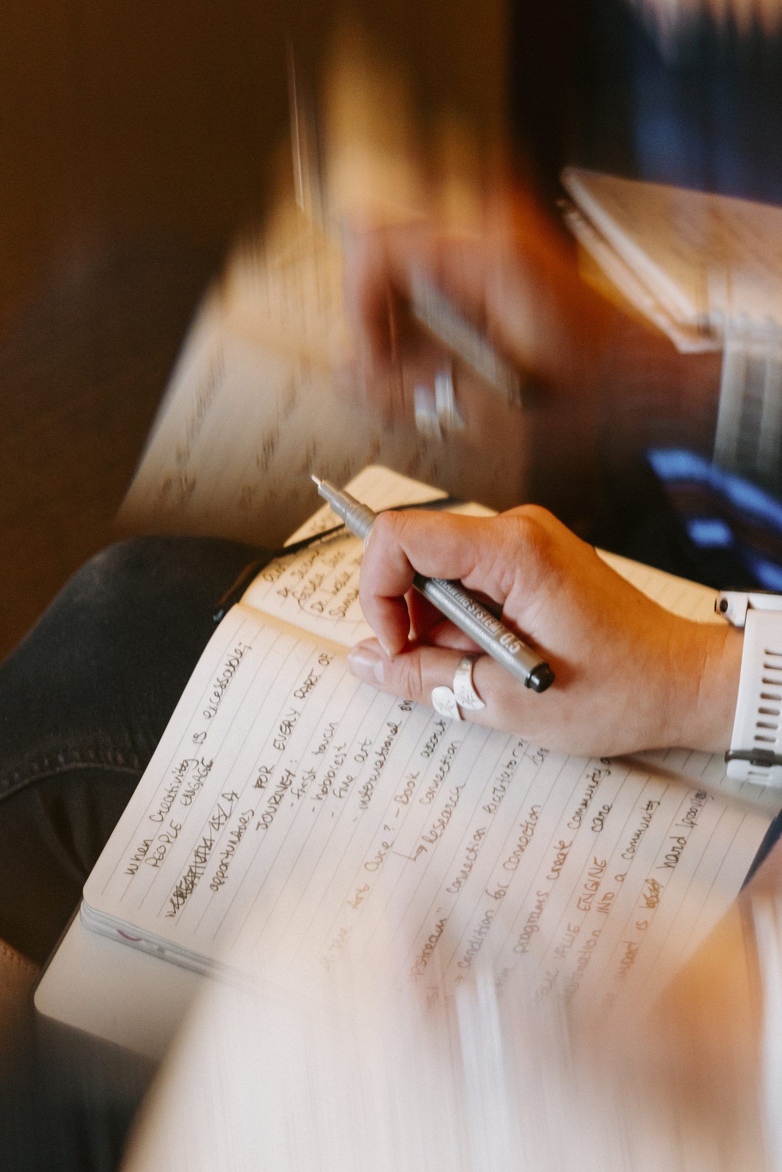 A hand writing notes in a notebook
