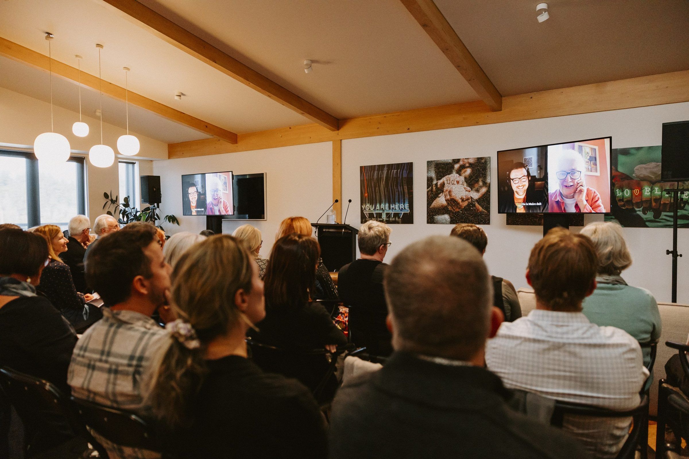 A full room at the hui, speakers joining on screen