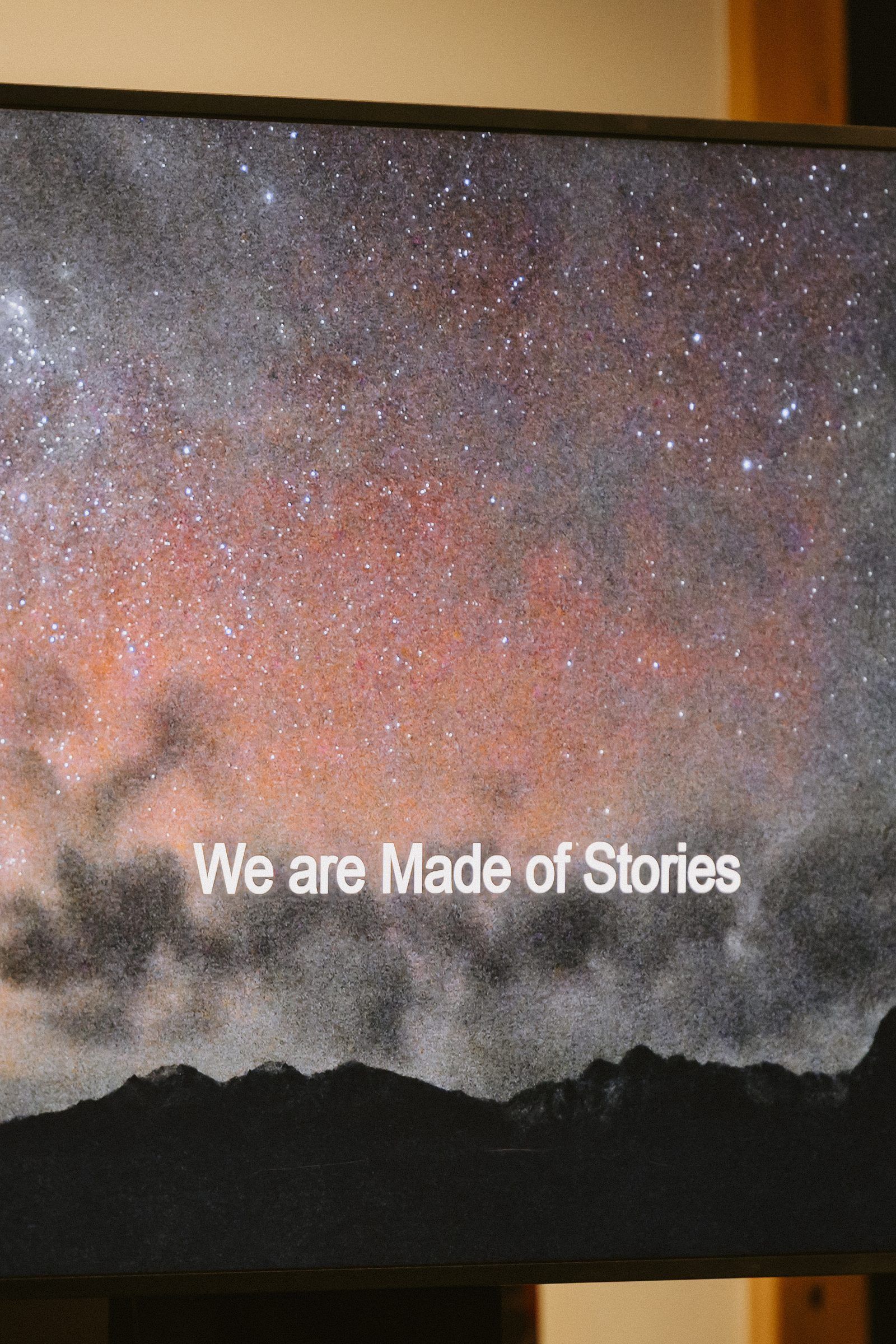A screen showing a starry night sky and the words We are Made of Stories