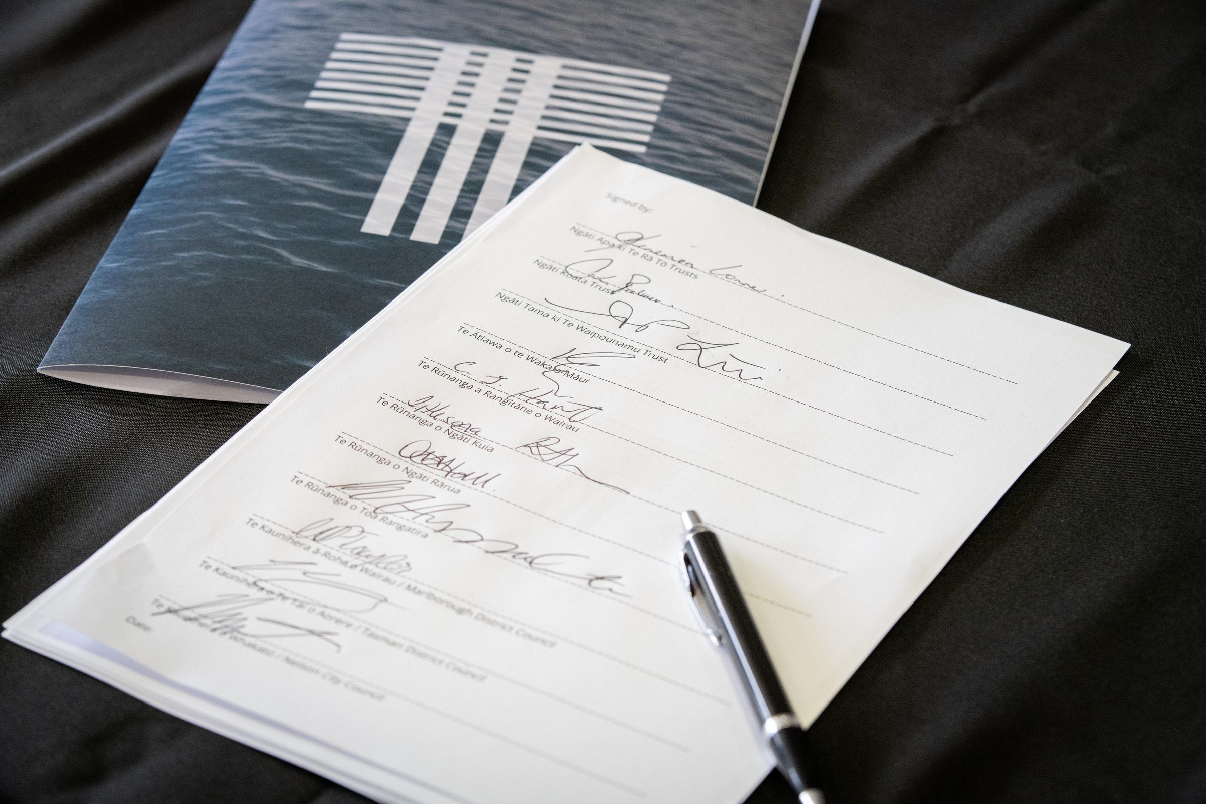The signed agreement with a pen resting on it